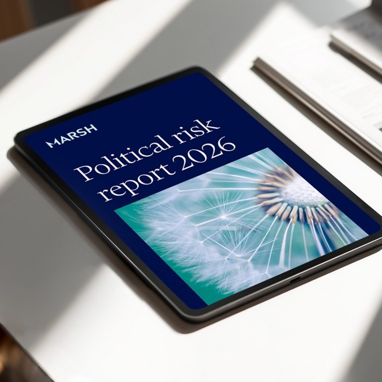 Photograph of a tablet showing Marsh Political Risk Report 2026 cover, a digital briefing on geopolitical risk trends.
